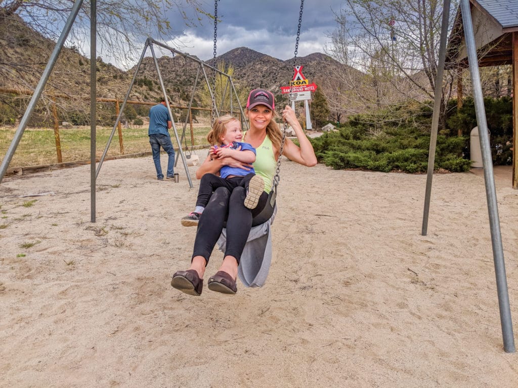 woman and toddler swinging at playground