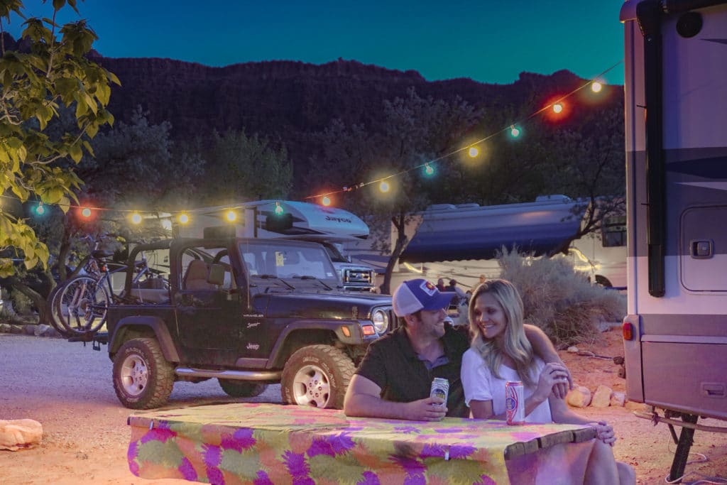 couple camping with string lights 
