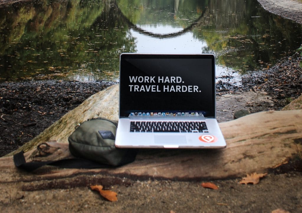 computer outdoors that says work hard travel harder